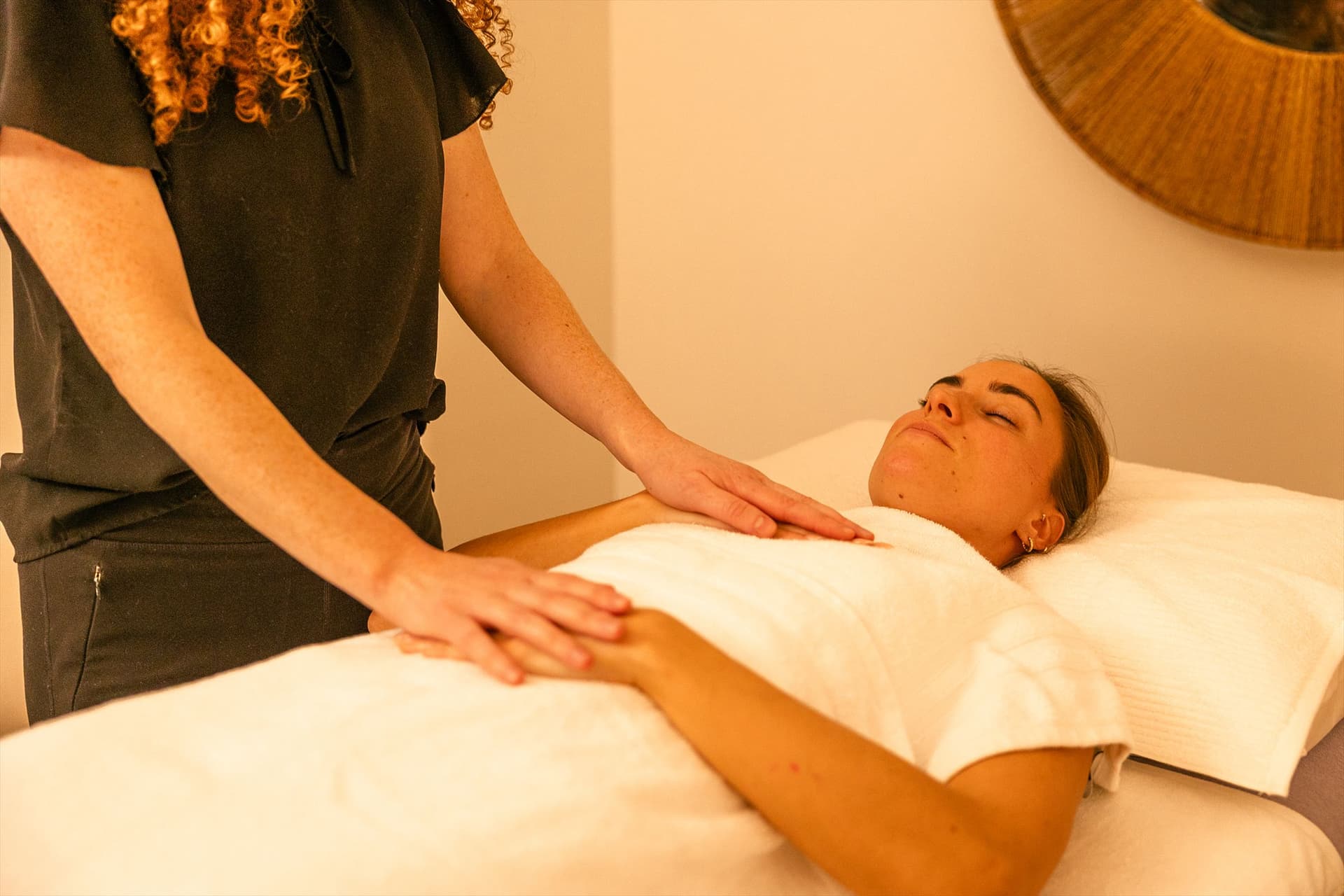 Rosie resting her hands on a relaxed client during a treatment