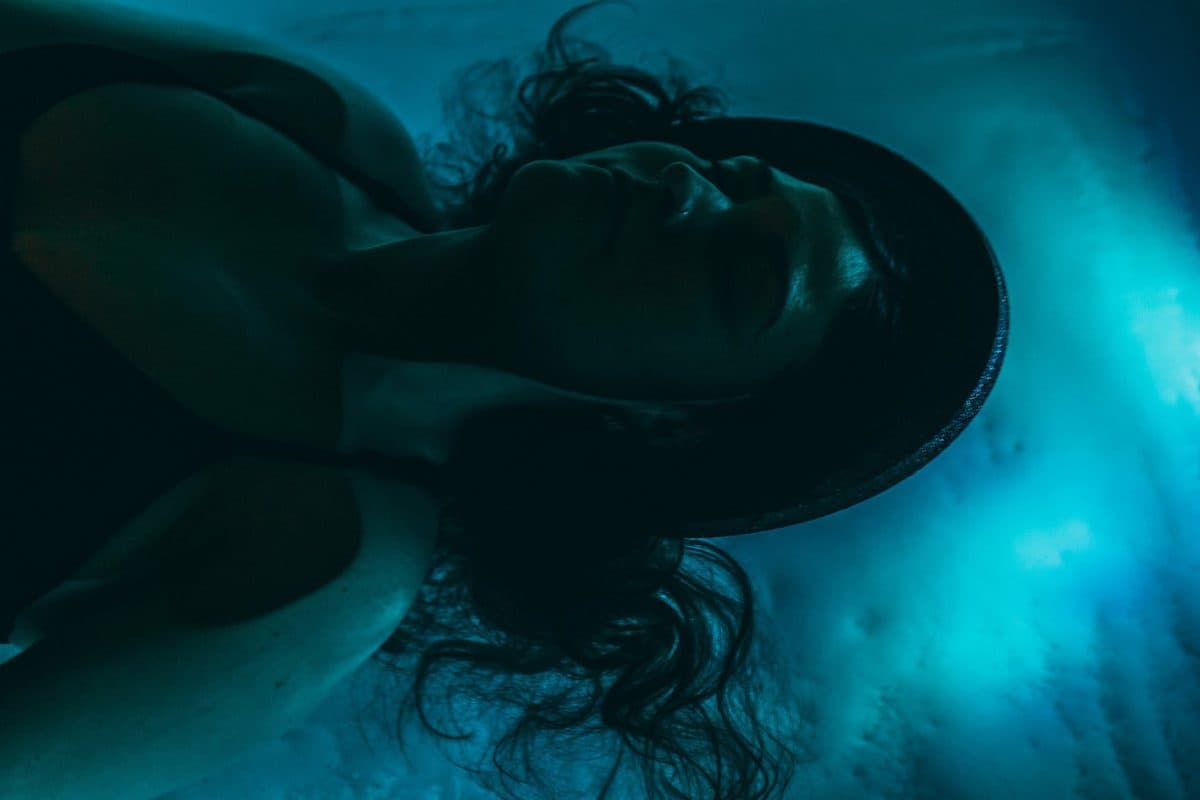 Person floating in a softly lit float tank
