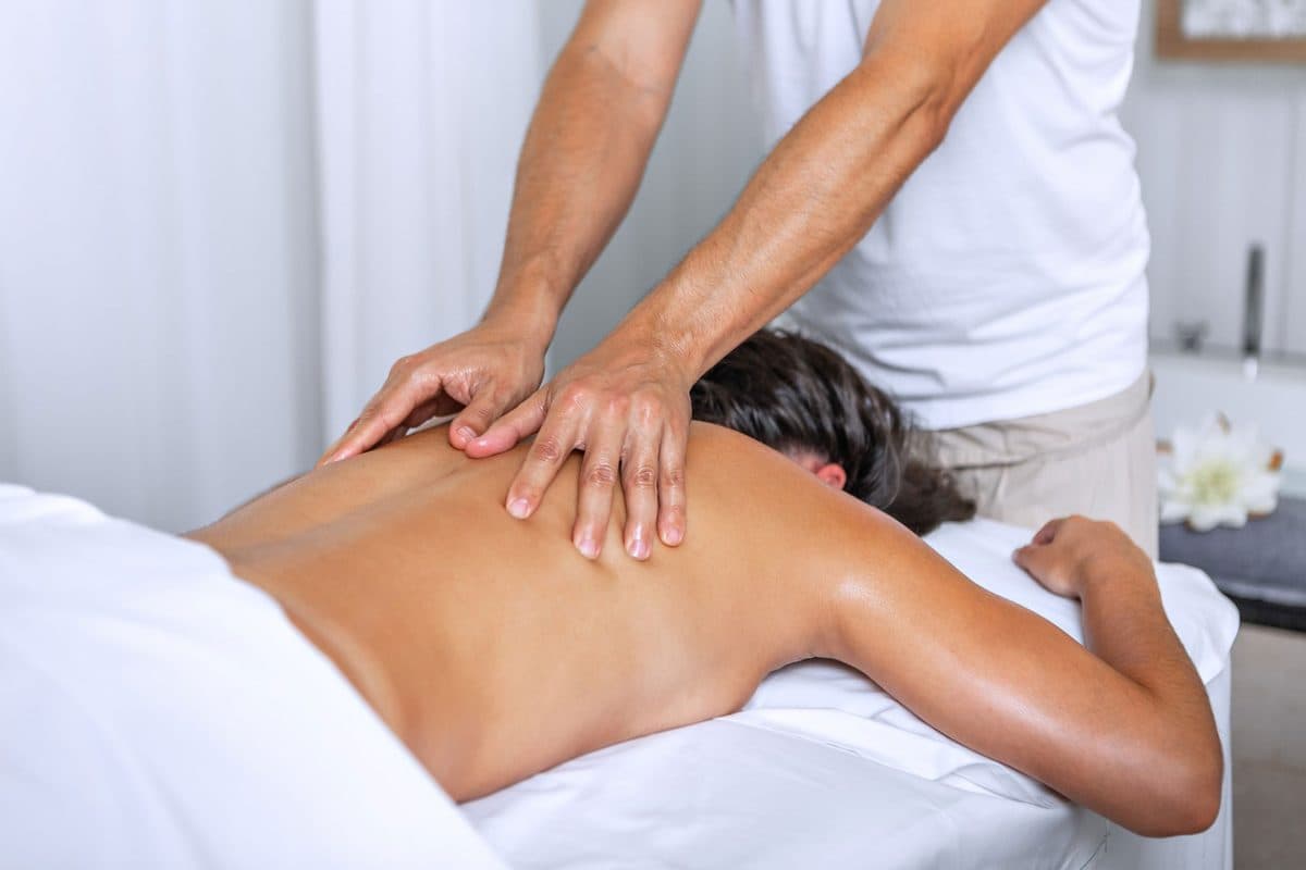 Massage therapist treating a client's back