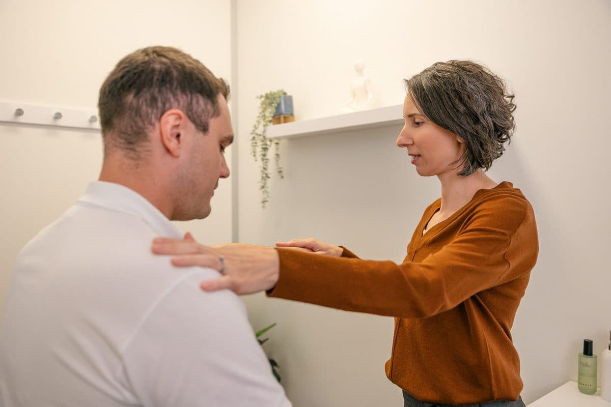 Practitioner assessing a client's shoulder